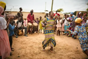 Traditional Ghanaian dance performed in a village circle with drummers